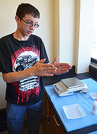 Green River High School student Brian Nussbaum explains his project in a University of Wyoming Department of Chemistry laboratory. He is taking part in the six-week Summer Research Apprentice Program that helps promote interest in science careers. (UW Photo)